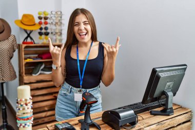 Genç esmer kadın perakende dükkanında açık mesajla pankart tutuyor çılgın bir ifadeyle bağırıyor elleri havada rock sembolü yapıyor. Müzik yıldızı. ağır müzik konsepti. 