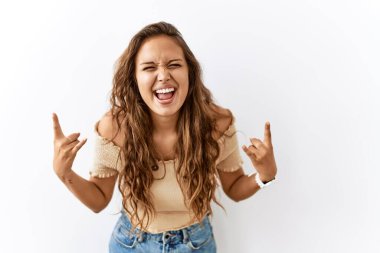 Güzel İspanyol kadın arka planda dikilirken çılgın bir ifadeyle elleri havada rock sembolü yaparken bağırıyor. Müzik yıldızı. ağır kavram. 