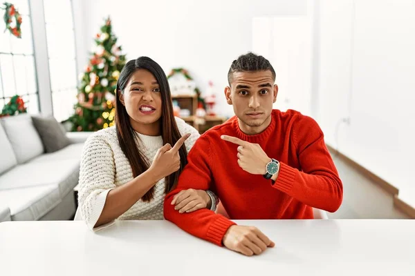 Jong Latijn Paar Zitten Tafel Door Kerstboom Terzijde Wijzen Bezorgd — Stockfoto