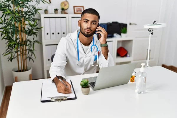 Jovem Homem Oriente Médio Vestindo Uniforme Médico Falando Smartphone Clínica — Fotografia de Stock