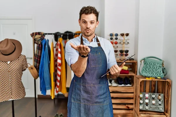 Perakende mağazasında yönetici olarak çalışan yakışıklı genç bir adam kameraya bakıp havada öpücükler savuruyor. Güzel ve seksi. aşk ifadesi. 