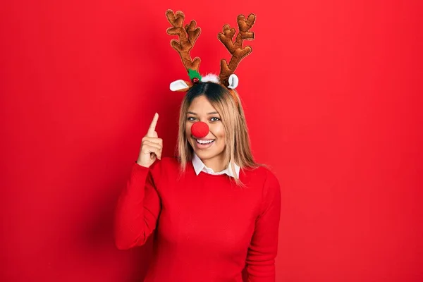 Krásná Hispánka Jelením Vánočním Kloboukem Červeným Nosem Ukazujícím Prstem Nahoru — Stock fotografie