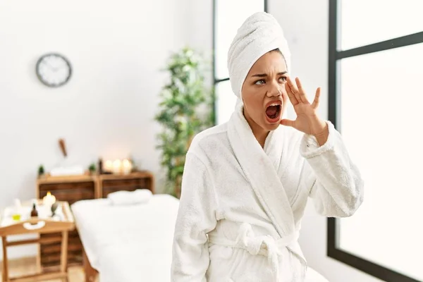 Young Brunette Woman Wearing Towel Bathrobe Standing Beauty Center Shouting — Stockfoto
