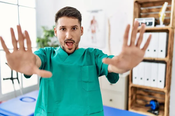 Young Physiotherapist Man Working Pain Recovery Clinic Doing Stop Gesture — Stockfoto