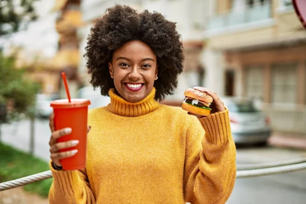 年轻的非洲裔美国女孩在城里吃着经典的汉堡包和苏打水 — 图库照片