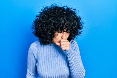 Orta Doğulu genç bir kadın günlük kıyafetler giyip kendini kötü hissediyor ve soğuk algınlığı veya bronşitin belirtisi olarak öksürüyor. sağlık hizmeti kavramı. 