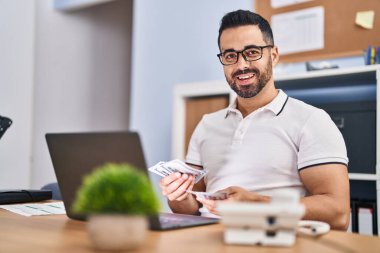 Genç İspanyol iş adamı ofiste çalışan paraları sayıyor.