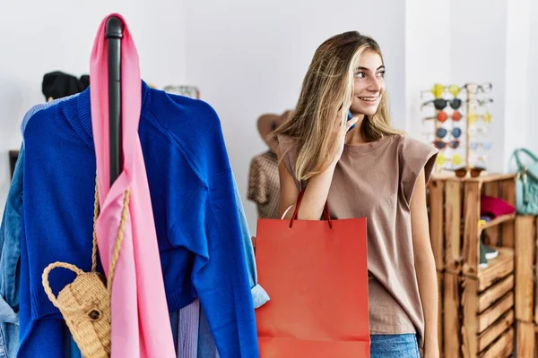 年轻的高加索女人在服装店用智能手机购物 — 图库照片