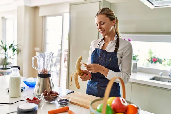 Joven Mujer Rubia Sonriendo Seguro Pelando Plátano Cocina —  Fotos de Stock