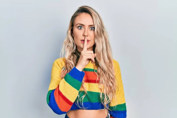 Piękna Młoda Blondynka Ubrana Kolorowy Sweter Prosząca Ciszę Palcem Ustach — Zdjęcie stockowe