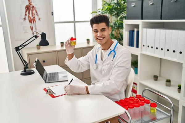 Young Hispanic Man Wearing Doctor Uniform Analysing Urine Test Tube — ストック写真