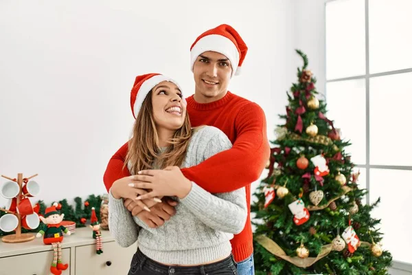 Jovem Casal Abraçando Sorrindo Feliz Vestindo Chapéu Natal Casa — Fotografia de Stock