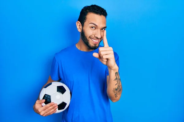 Hombre Hispano Con Barba Sosteniendo Pelota Fútbol Apuntando Con Dedo — Foto de Stock