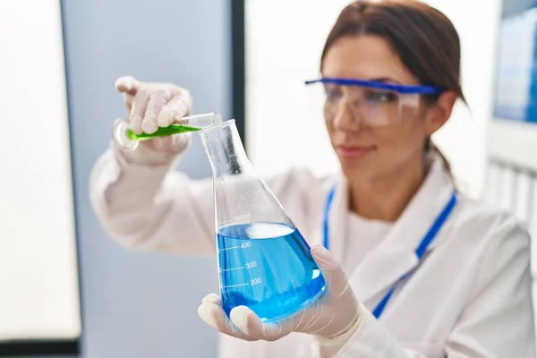 Young Hispanic Woman Wearing Scientist Uniform Measuring Liquid Laboratory — Φωτογραφία Αρχείου