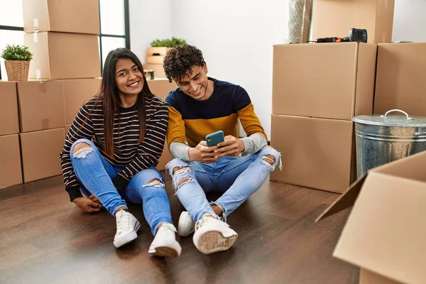 Young Latin Couple Using Smartphone Sitting Floor New Home — Stock Photo, Image