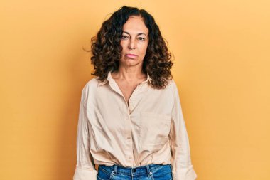 Orta yaşlı İspanyol kadın, günlük giysiler giyiyor, depresyonda ve endişe içinde, kızgın ve korkmuş bir şekilde ağlıyor. hüzünlü ifade. 