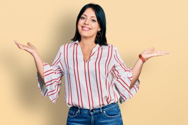 Gündelik kıyafetler giyen, elleri ve kolları havada, kafası karışmış genç İspanyol kız. şüphe kavramı. 