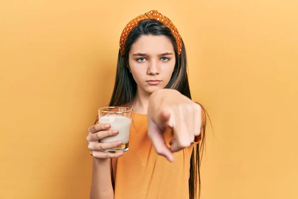Νεαρή Μελαχρινή Κοπέλα Που Πίνει Ένα Ποτήρι Γάλα Δείχνοντας Δάχτυλο — Φωτογραφία Αρχείου