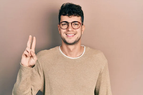 Gündelik Kıyafetler Giyen Gözlüklü Genç Spanyol Adam Iki Numarayı Gösterip — Stok fotoğraf