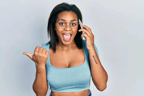 Joven Afroamericana Chica Teniendo Conversación Hablando Teléfono Inteligente Apuntando Pulgar — Foto de Stock