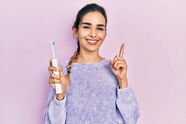 Junges Hispanisches Mädchen Mit Elektrischer Zahnbürste Lächelnd Mit Einer Idee — Stockfoto