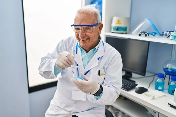 研究室で科学者の均一な混合液を身に着けているシニア男 — ストック写真