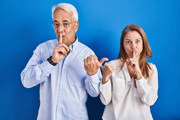 Pareja Hispana Mediana Edad Pie Sobre Fondo Azul Pidiendo Silencio —  Fotos de Stock