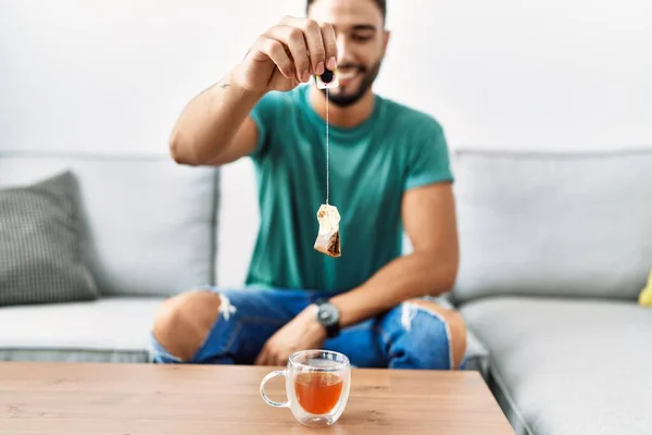 Jonge Arabier Man Glimlachend Zelfverzekerd Houden Theezakje Thuis — Stockfoto