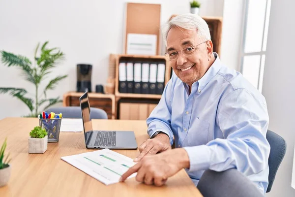 Ofiste çalışan orta yaşlı erkek ve kadın işçiler.