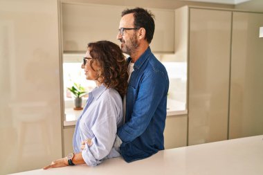 Orta yaşlı çift yan yana durup, profillerini rahatlatmak için doğal bir yüz ve kendine güvenen bir gülümseme takınıyorlar.. 