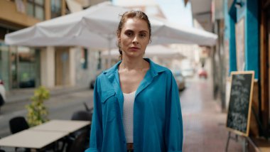 Sokakta duran rahat yüzlü genç kadın.