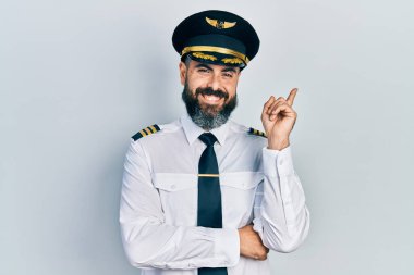 Yüzünde kocaman bir gülümseme olan, uçak pilotu üniforması giyen genç İspanyol adam, kameraya el ve parmak ile bakıyor.. 