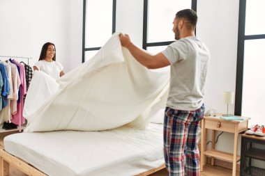 Genç Latin çift gülümsüyor, mutlu mesut evlerinde yatıyorlar..