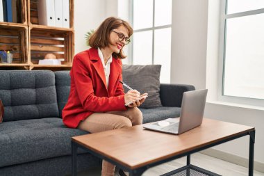 Beyaz kadın psikolog psikoloji merkezinde online danışmanlık yapıyor.