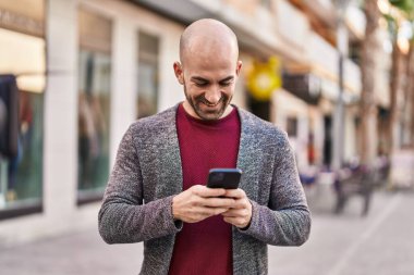 Sokakta akıllı telefon kullanan kendine güvenen genç adam.