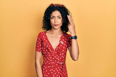 Genç Latin kız yaz elbisesi giyip kendini vuruyor ve kendini öldürüyor. Elini ve parmaklarını silah gibi kullanıyor. İntihar jesti.. 