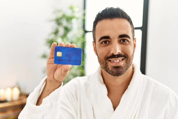 Young Hispanic Man Wearing Bathrobe Holding Credit Card Beauty Center — Stock Fotó