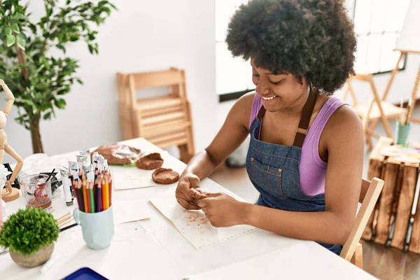 年轻的非洲裔美国女人微笑着自信地在艺术工作室操纵粘土 — 图库照片