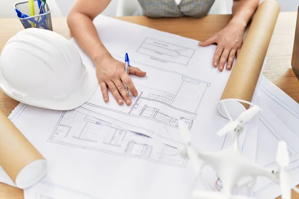 Young caucasian woman writing on architect plan working at architecture studio