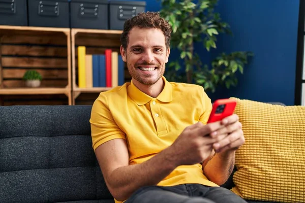 Jovem Hispânico Usando Smartphone Sentado Sofá Casa — Fotografia de Stock