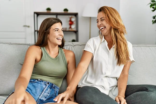 Madre Hija Sonriendo Confiadas Sentadas Sofá Casa —  Fotos de Stock