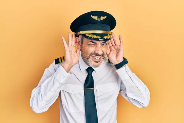 Snygg Medelålders Man Med Grått Hår Flygplansuniform Som Försöker Höra — Stockfoto