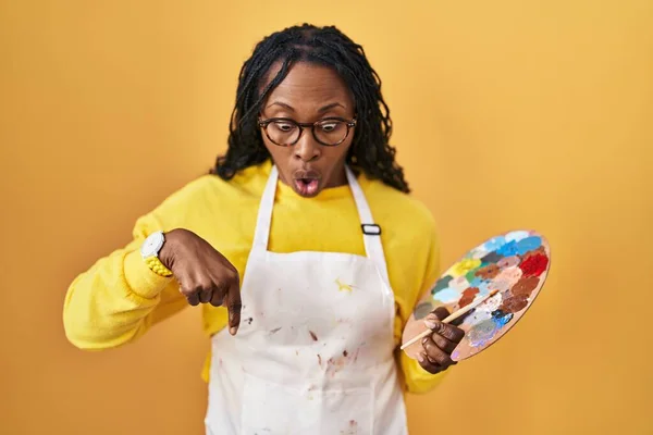 African Woman Holding Painter Palette Pointing Fingers Showing Advertisement Surprised — Stockfoto