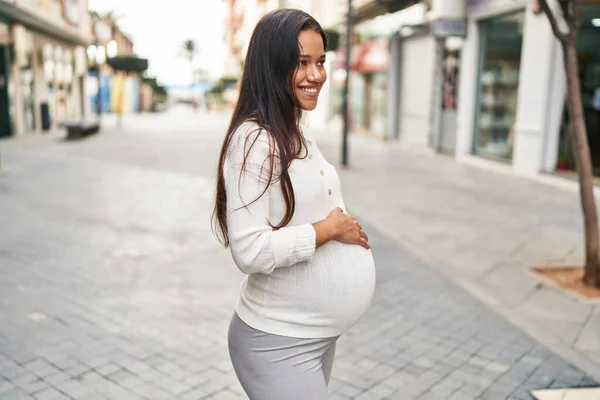 Młoda Latynoska Kobieta Ciąży Uśmiecha Się Pewnie Dotykając Brzucha Ulicy — Zdjęcie stockowe