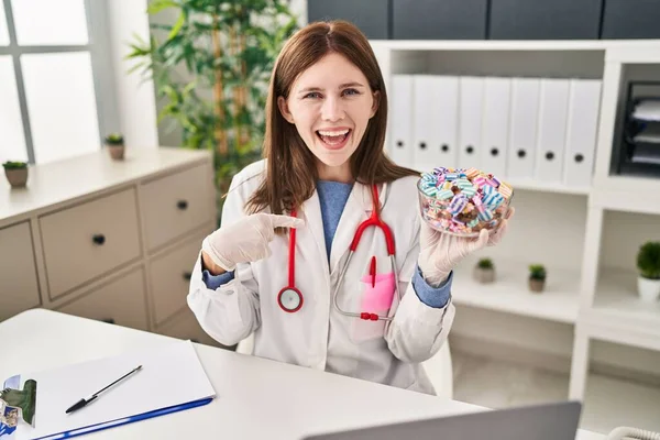 Young Doctor Woman Holding Sweets Candy Pointing Finger One Self — ストック写真
