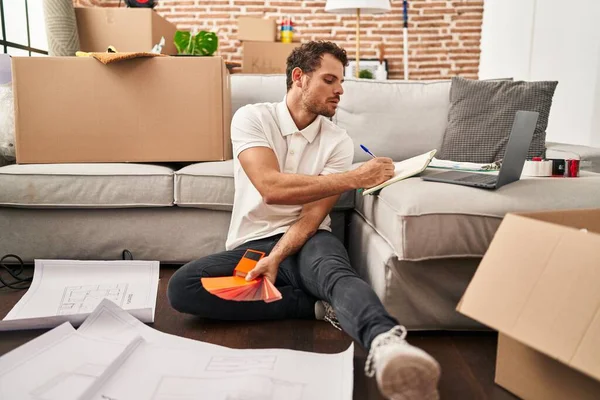 Jonge Spaanse Man Schrijven Boek Kiezen Verf Kleur Nieuw Huis — Stockfoto