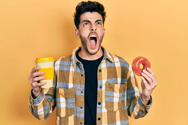 Νεαρός Ισπανός Τρώει Ντόνατ Και Πίνει Καφέ Θυμωμένος Και Θυμωμένος — Φωτογραφία Αρχείου