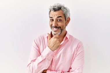 Orta yaşlı İspanyol bir adam izole edilmiş arka planda duruyor kameraya bakıyor kollarını kavuşturmuş ve çenesini kaldırmış gülümsüyor. Olumlu düşünmek. 