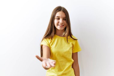 Genç esmer ergen, izole edilmiş arka planda yan yana durup gülümseyerek avuçlarını açıp yardım ve kabullenme teklif ediyor.. 