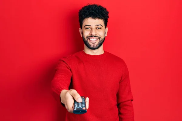 Молодий Арабський Чоловік Бородою Тримає Телевізійний Пульт Дистанційного Керування Посміхаючись — стокове фото